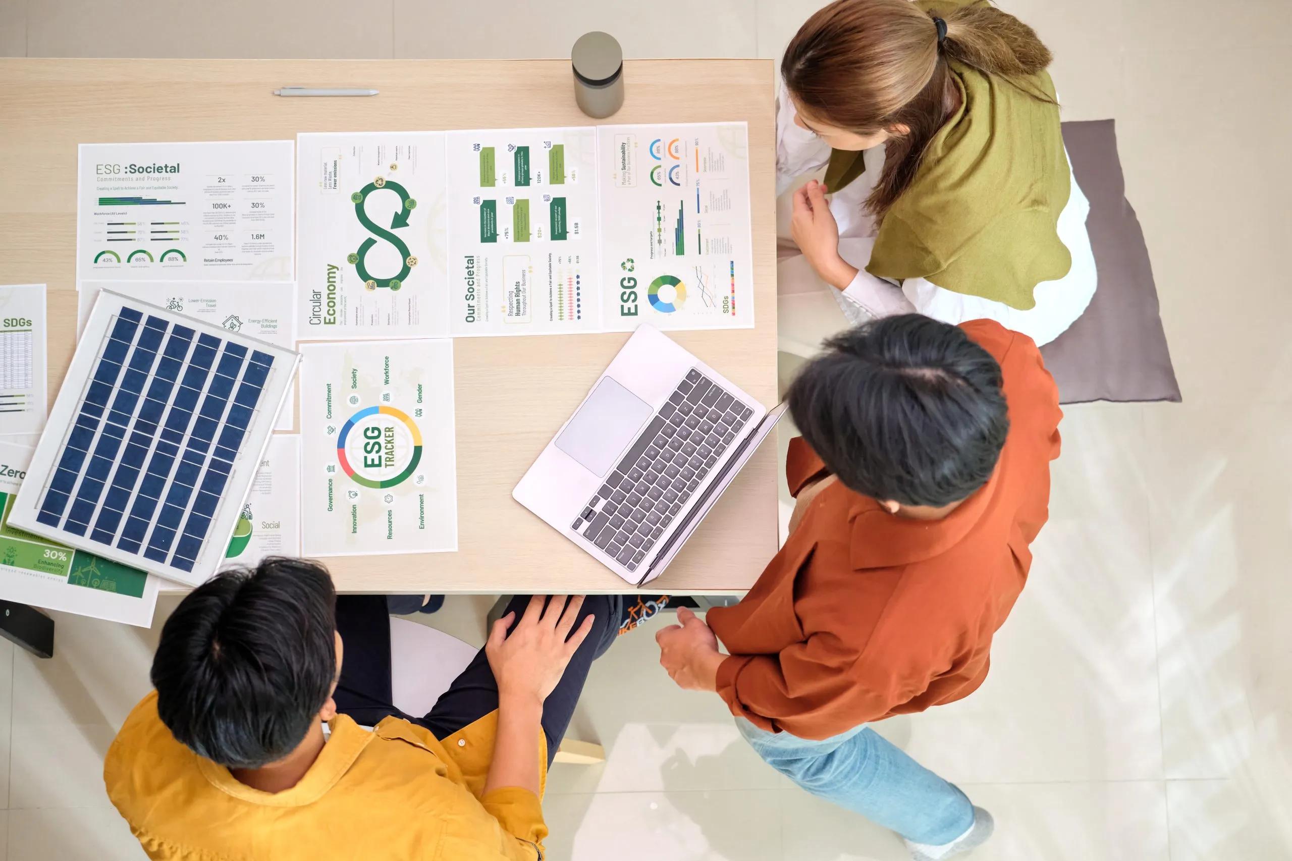 Team reviewing ESG reports around a table, viewed from above