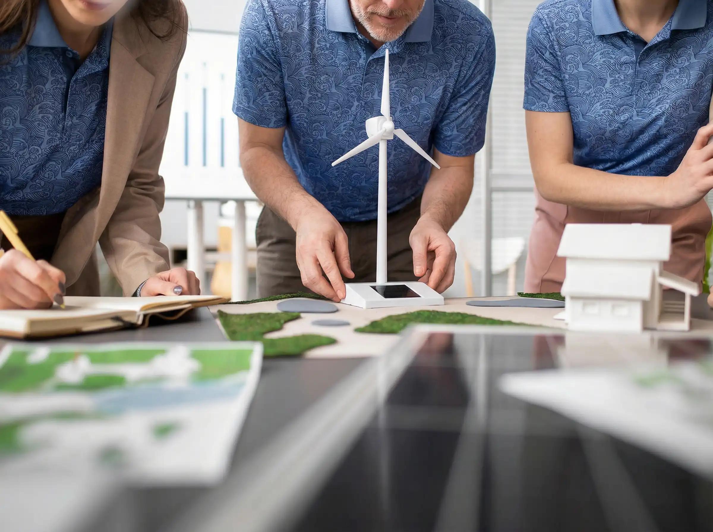 Team planning sustainability goals with a wind-turbine model and ESG reports